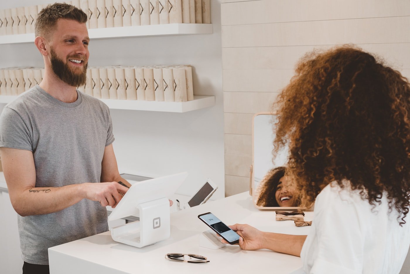 Customer tapping a card on a payment terminal at checkout