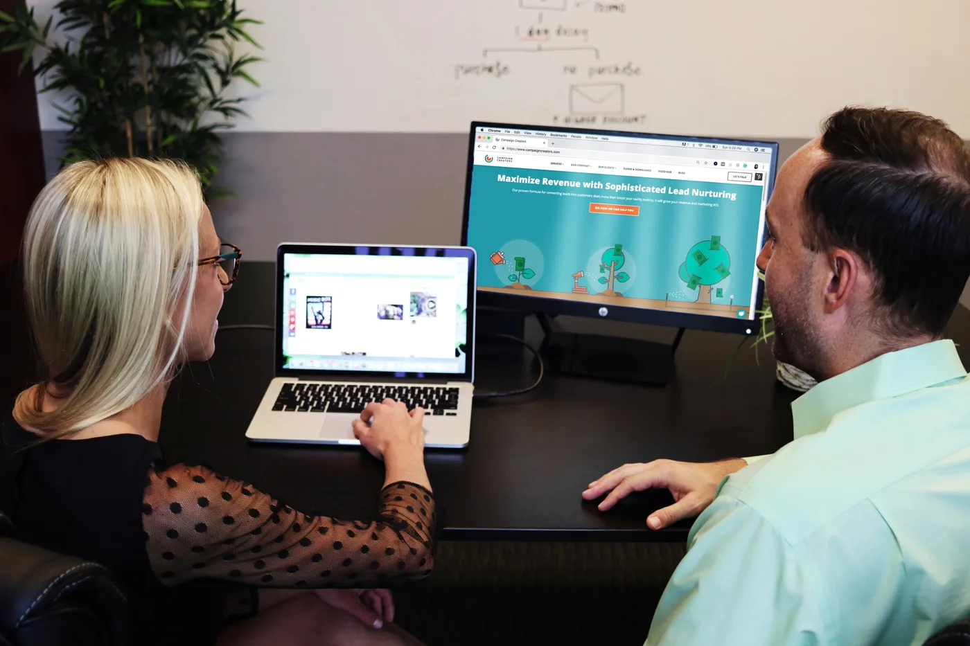 Designer presenting a design system and handoff documentation to a client at a desk